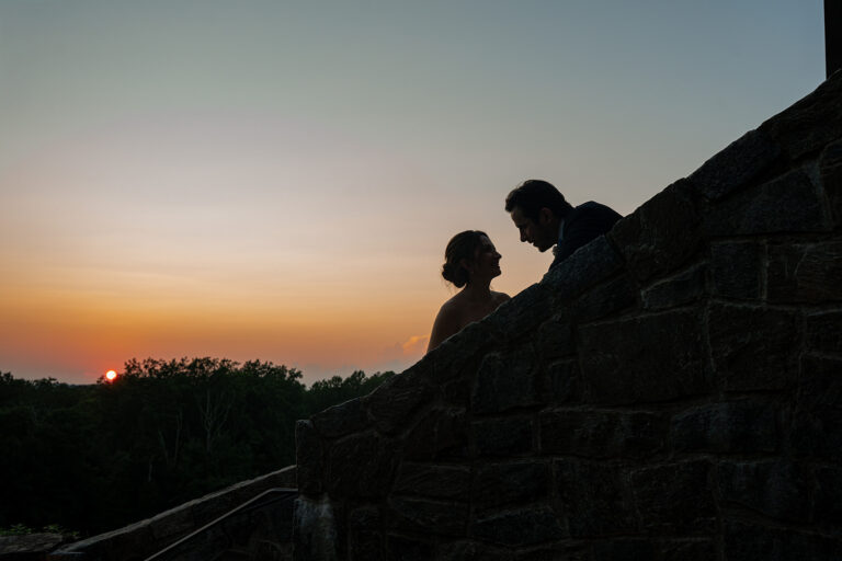 Wedding couple staring at each other lovingly at Le Chateau in South Salem New York as the sun is setting creating a silhouette.