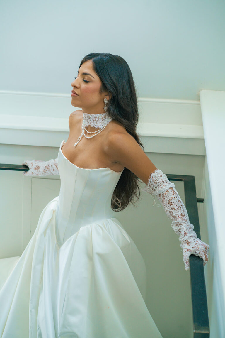 Bride in a Berta Bridal gown posing looking up and the gown falls beautiful from her neck down her torso at Mari Mi Bridal Salon in Philadelphia, Pennsylvania.